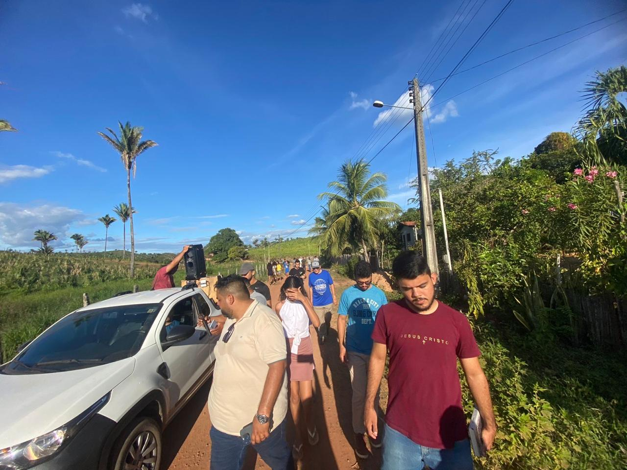 Mission team walking through a rural community with sound equipment